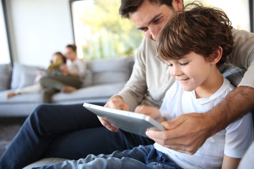 Pai e filho assistindo ou lendo no tablet juntos