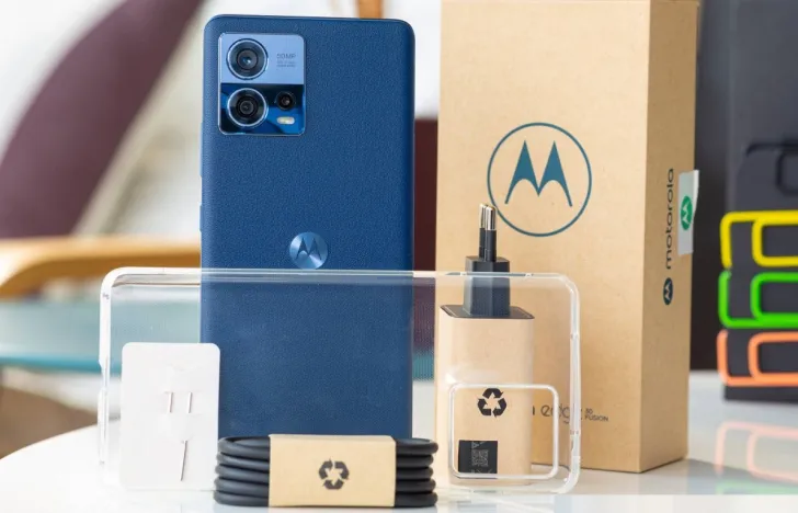 Motorola Edge 30 Fusion de cor azul junto aos seus acessórios presentes em cima de uma mesa.
