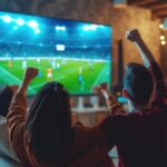 amigos assistindo futebol em uma televisão full hd ou 4k